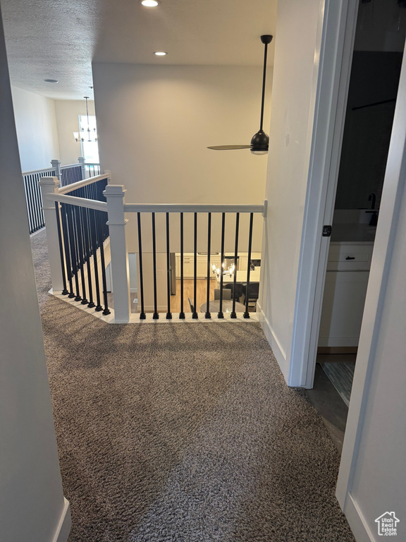 Hall featuring carpet, an upstairs landing, recessed lighting, and a chandelier