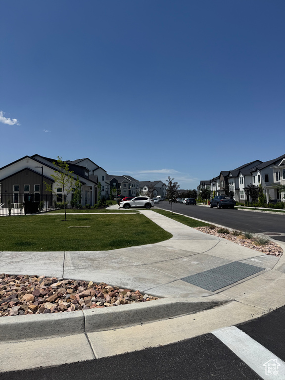 View of asphalt road featuring a residential view and sidewalks