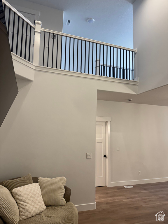 Living room with wood finished floors, baseboards, and a towering ceiling
