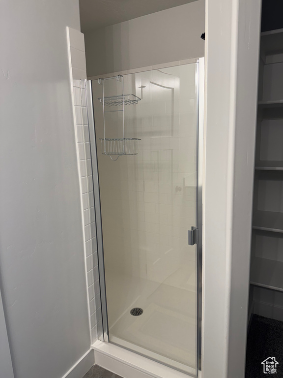 Bathroom featuring a stall shower and a spacious closet
