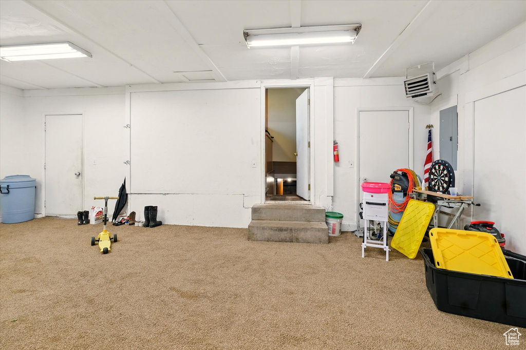 Basement featuring carpet floors, electric panel, and a heating unit