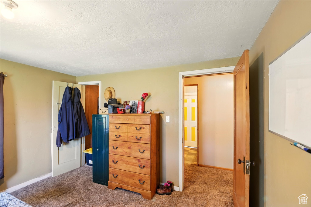 Bedroom featuring a textured ceiling, carpet floors, and baseboards