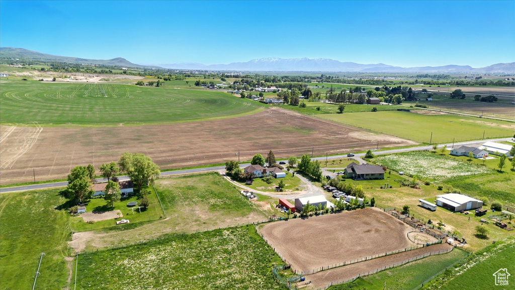 Aerial view of property and surrounding area featuring a mountain backdrop and rural landscape