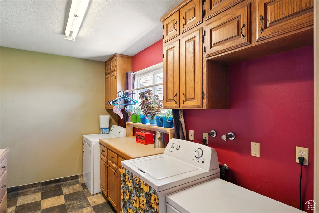 Laundry area with cabinet space, washer and dryer, dark flooring, and baseboards