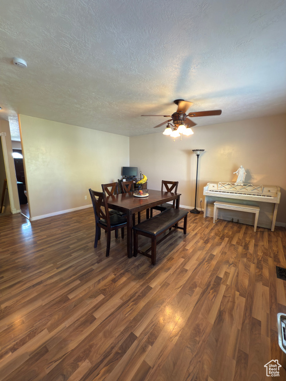Dining space featuring wood finished floors, a textured ceiling, and ceiling fan