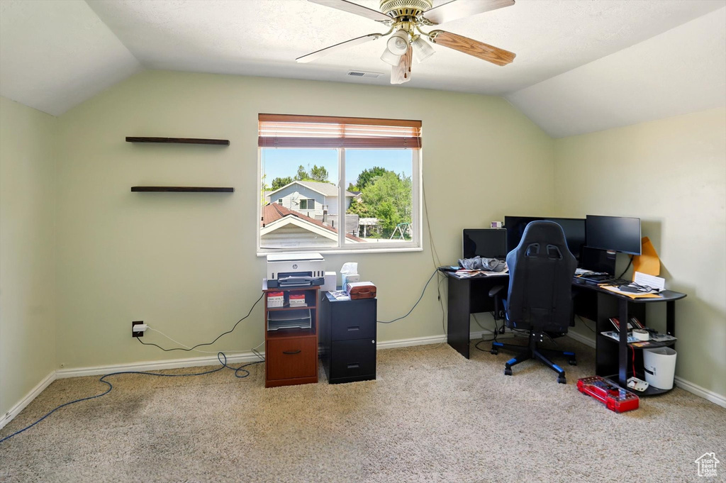 Carpeted office with vaulted ceiling, a ceiling fan, and baseboards