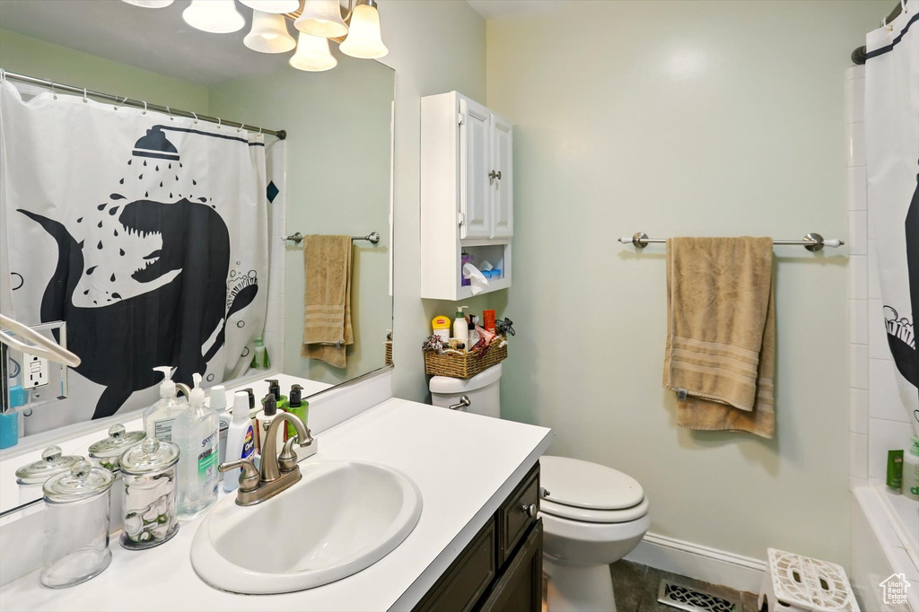 Full bathroom featuring vanity, a chandelier, toilet, and baseboards