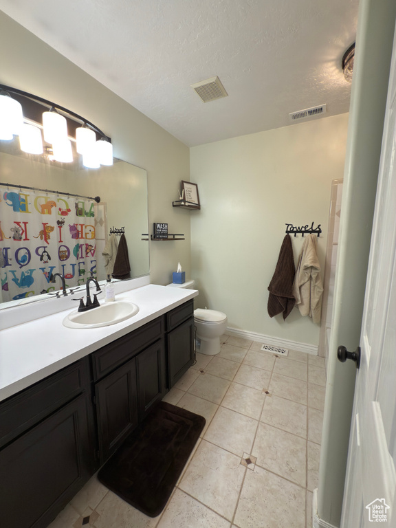 Bathroom with vanity, tile patterned floors, a textured ceiling, and a shower with shower curtain