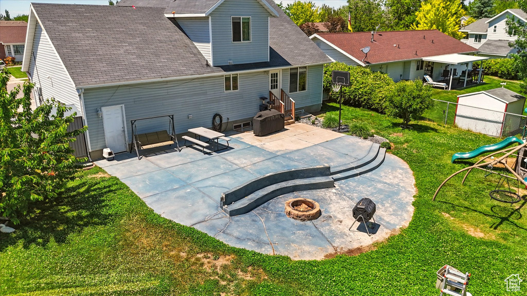 Rear view of house with an outdoor fire pit, a patio, and a shingled roof