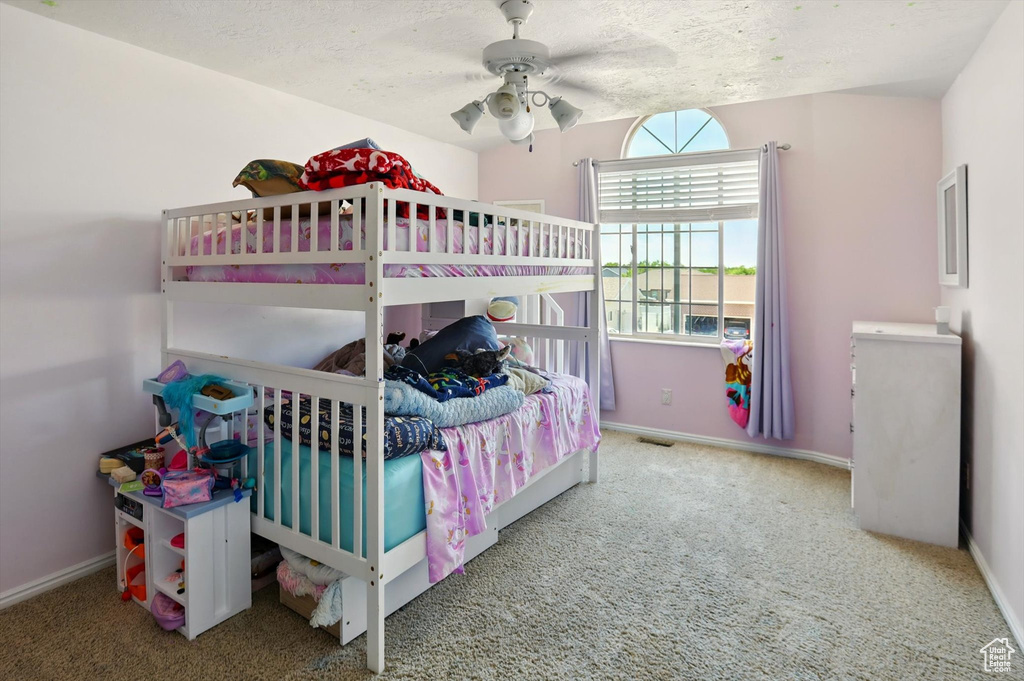 Bedroom with carpet, baseboards, a ceiling fan, and a textured ceiling