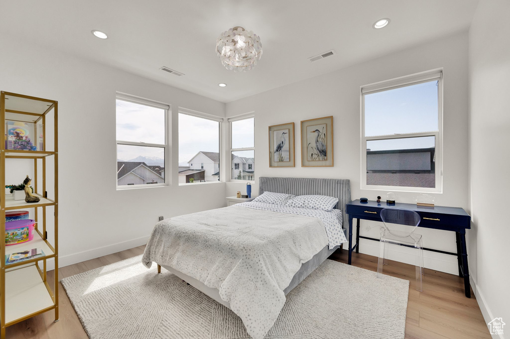 Bedroom with wood finished floors, recessed lighting, and baseboards
