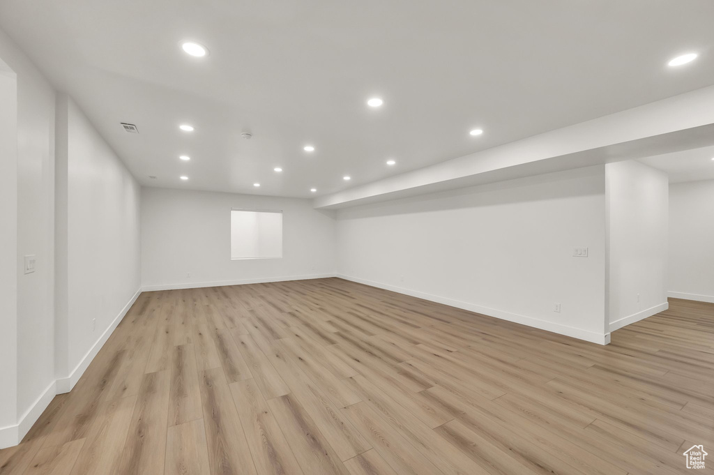 Finished basement featuring light wood-style floors, recessed lighting, and baseboards