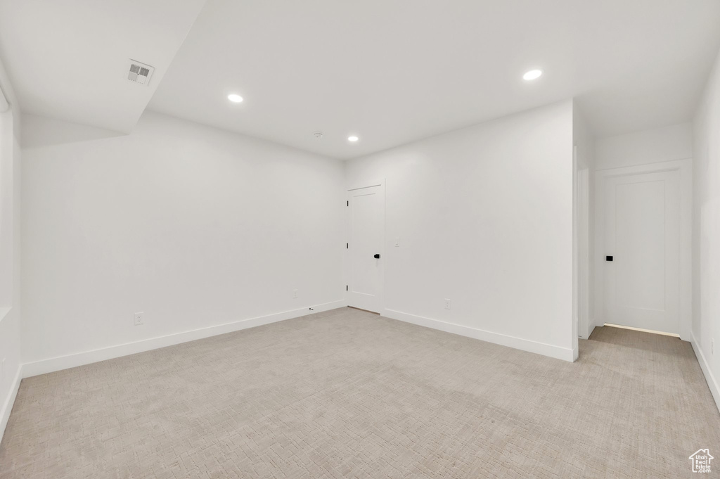 Unfurnished room with recessed lighting, light carpet, and baseboards