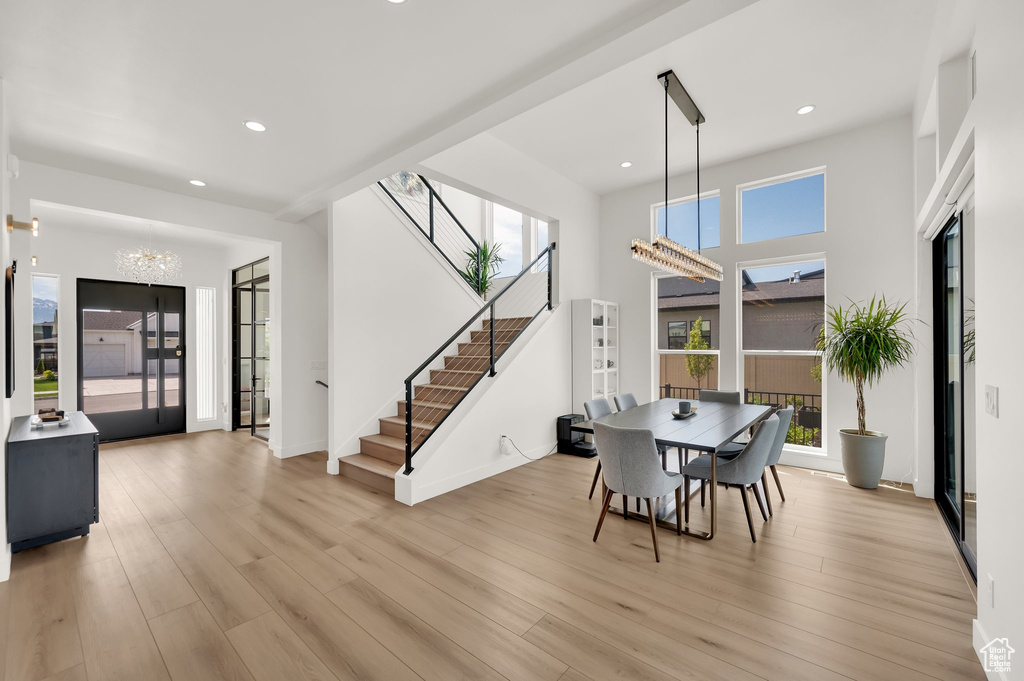Dining space with stairs, a chandelier, light wood-type flooring, recessed lighting, and baseboards
