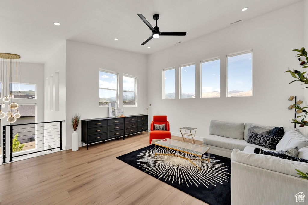 Living area featuring light wood-style flooring, ceiling fan, recessed lighting, and baseboards