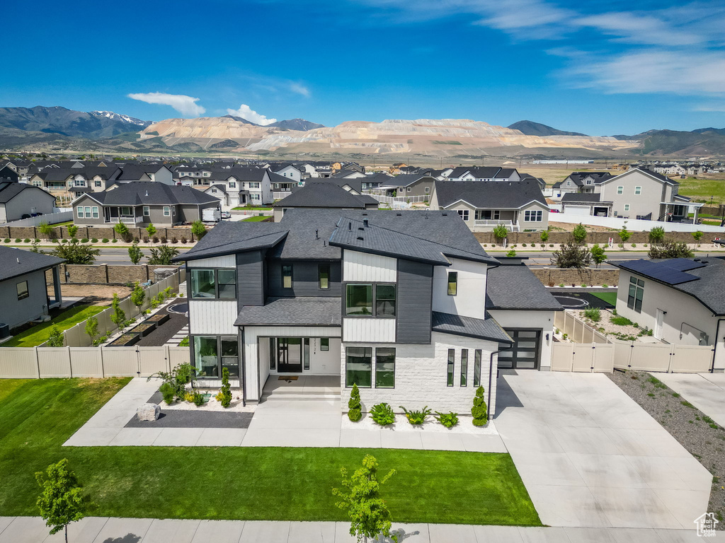 View of front of property with a residential view, a gate, roof with shingles, a mountain view, and concrete driveway