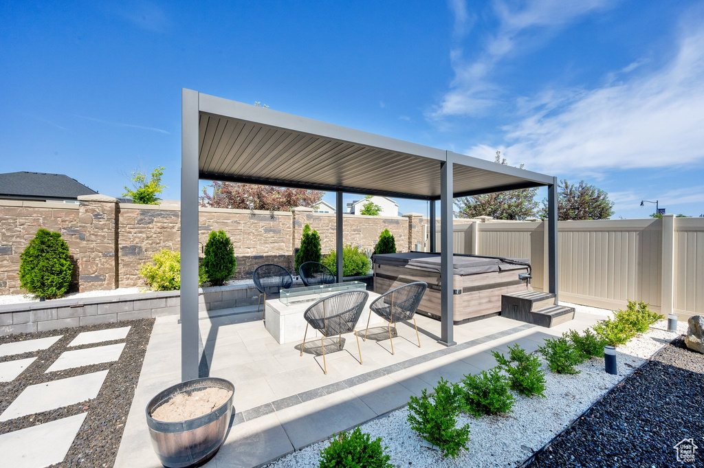 Fenced backyard featuring a hot tub and a patio area