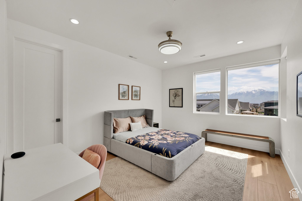 Bedroom with light wood finished floors, recessed lighting, and baseboards