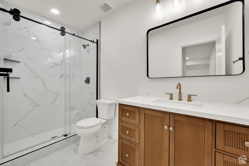 Full bathroom with toilet, marble look tiles, vanity, a marble finish shower, and recessed lighting