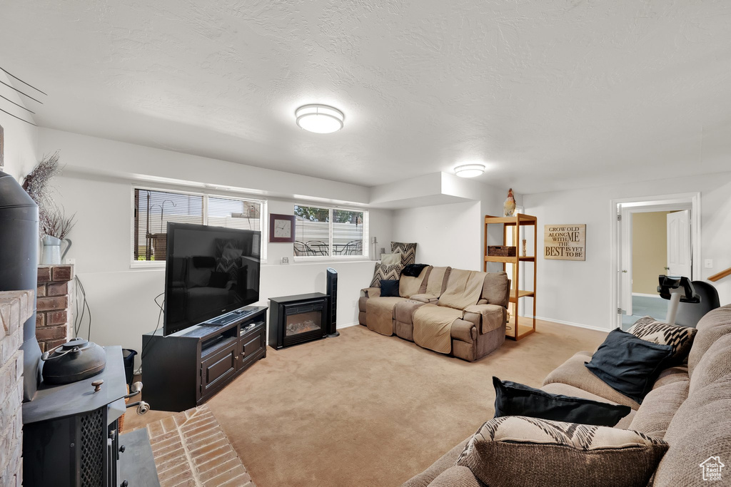 Living area featuring a fireplace, carpet, and baseboards