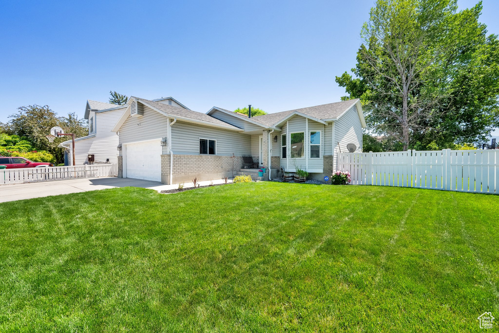 View of front of home featuring an attached garage, concrete driveway, brick siding, and a shingled roof