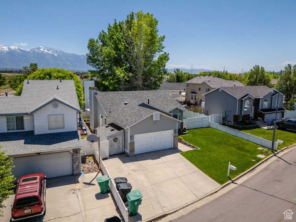 Traditional home with driveway, a residential view, a mountain view, roof with shingles, and a gate
