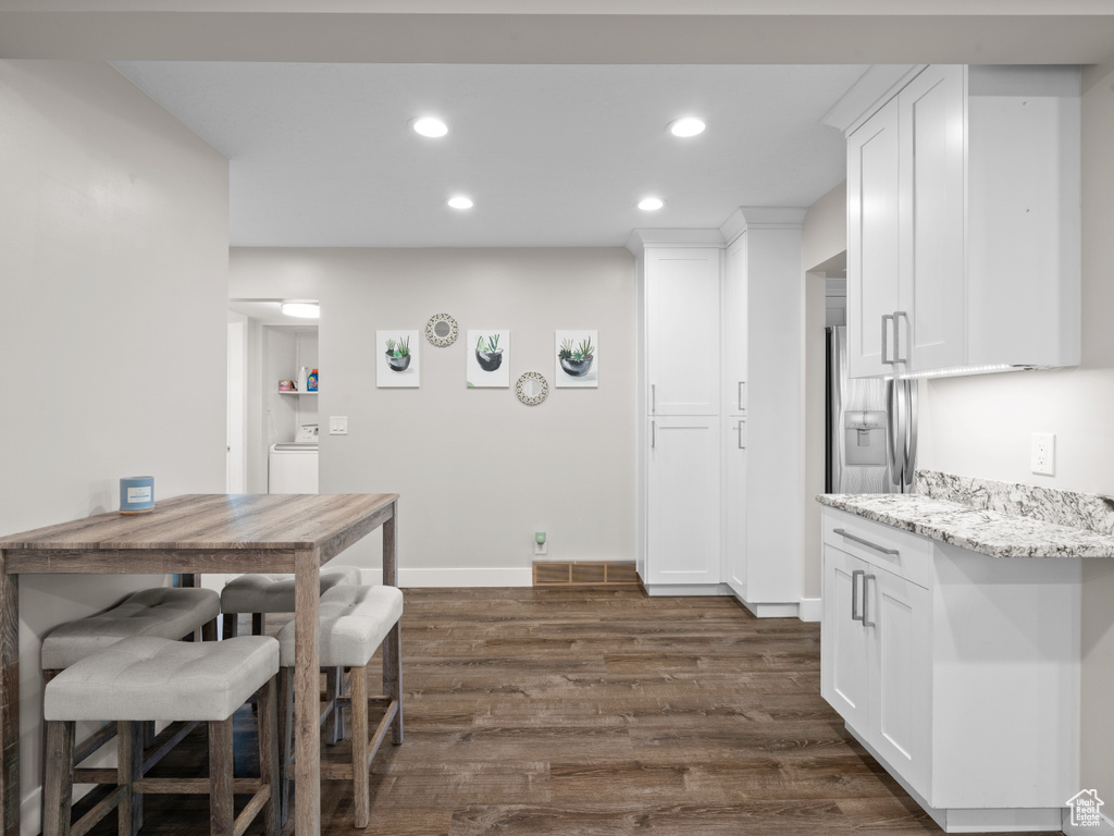 Dining area with dark wood finished floors, recessed lighting, baseboards, and washer / dryer