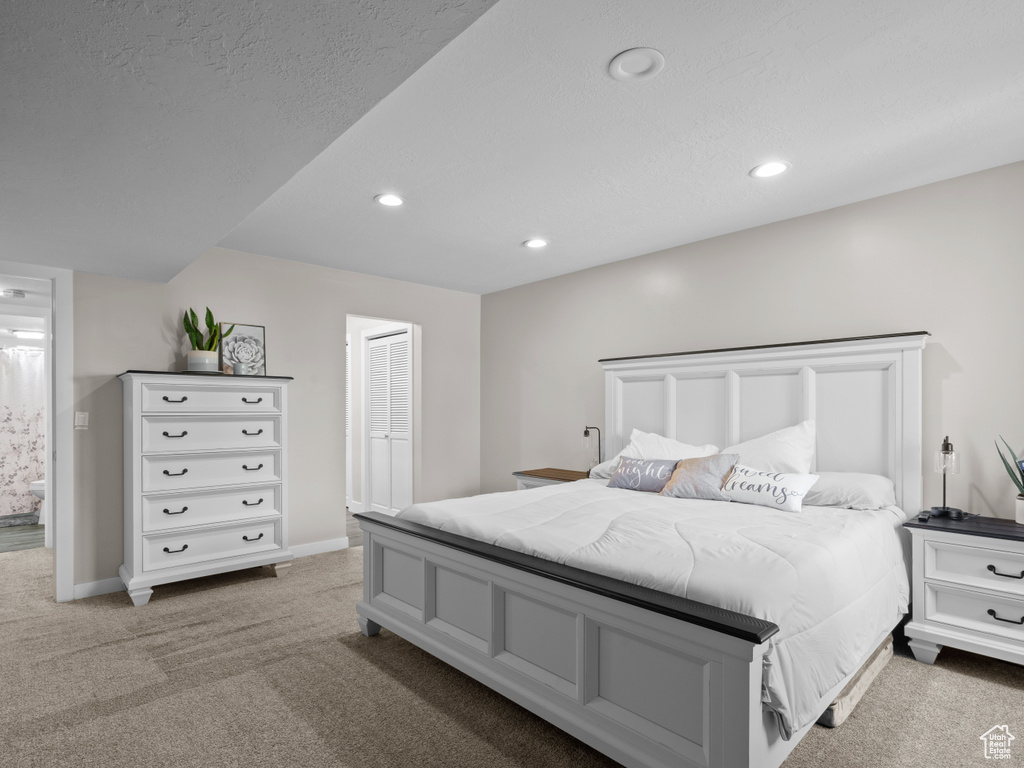 Bedroom with light carpet, recessed lighting, baseboards, and a closet
