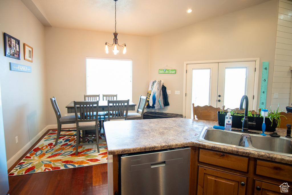 Kitchen featuring dishwasher, a sink, a chandelier, decorative light fixtures, and wood finished floors