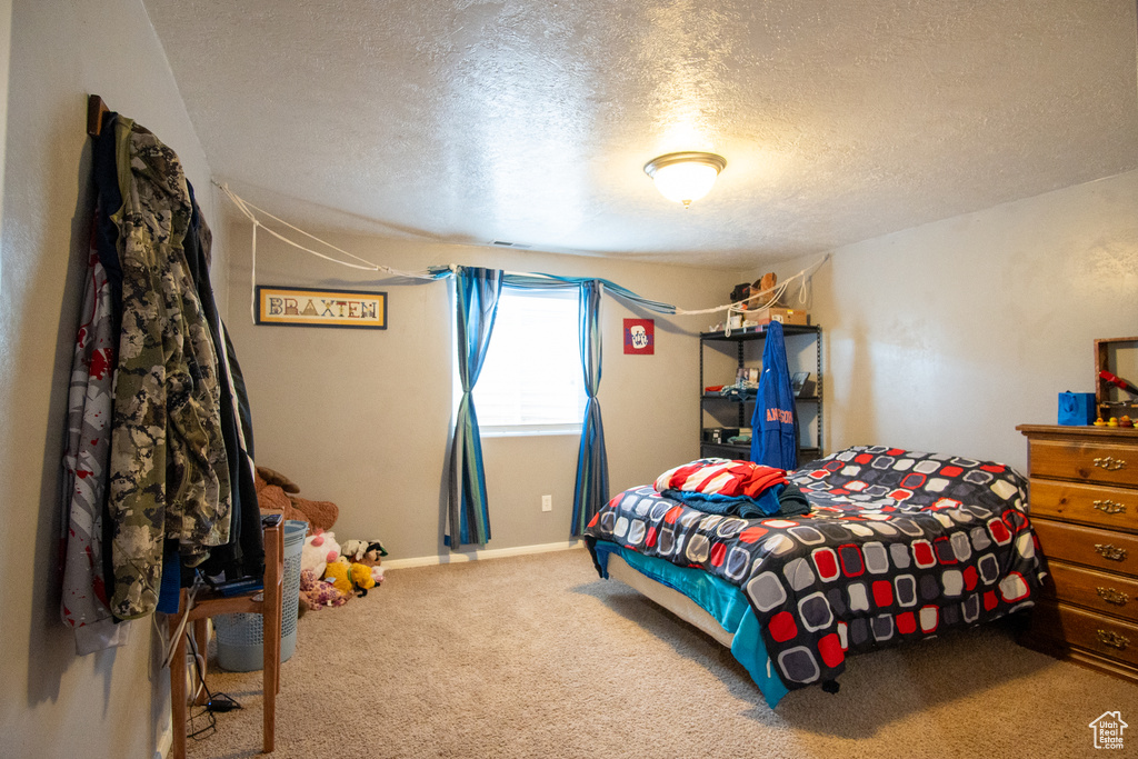 Bedroom with a textured ceiling and carpet flooring
