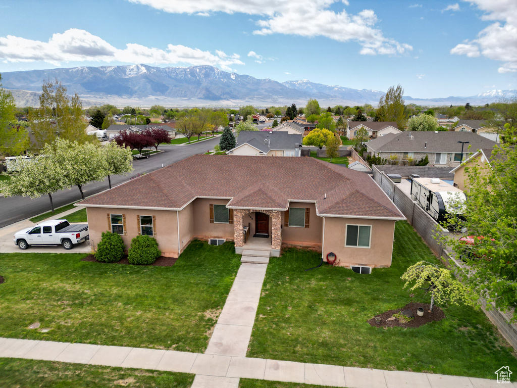 View of front of property with stucco siding, roof with shingles, and a mountain view