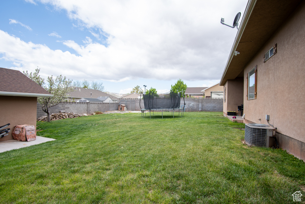 View of yard featuring central AC and a trampoline