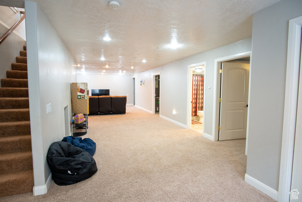 Finished below grade area with carpet flooring, baseboards, stairs, and recessed lighting