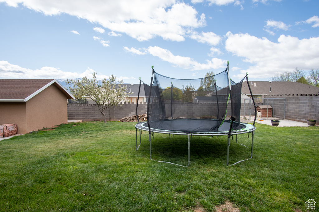 View of yard with a trampoline and a patio area