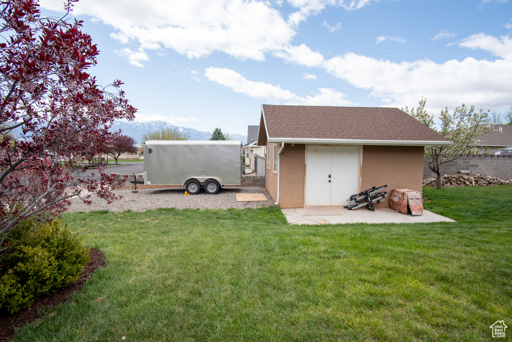 View of grassy yard featuring an outdoor structure