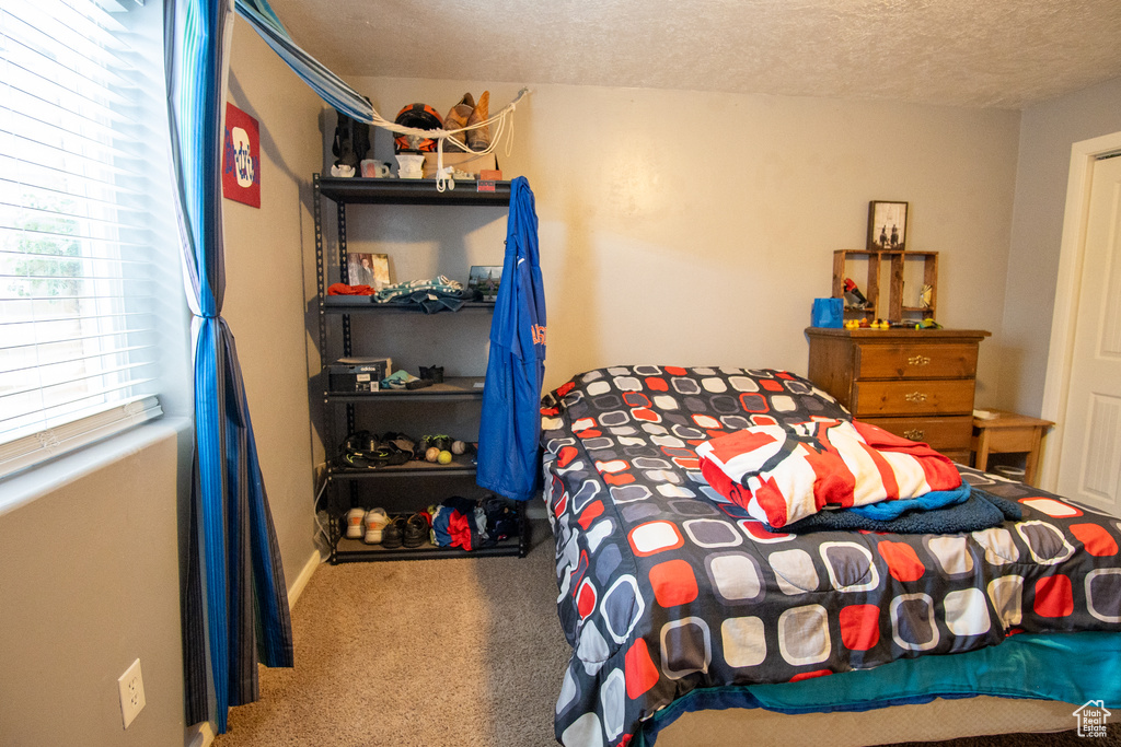Carpeted bedroom featuring a textured ceiling