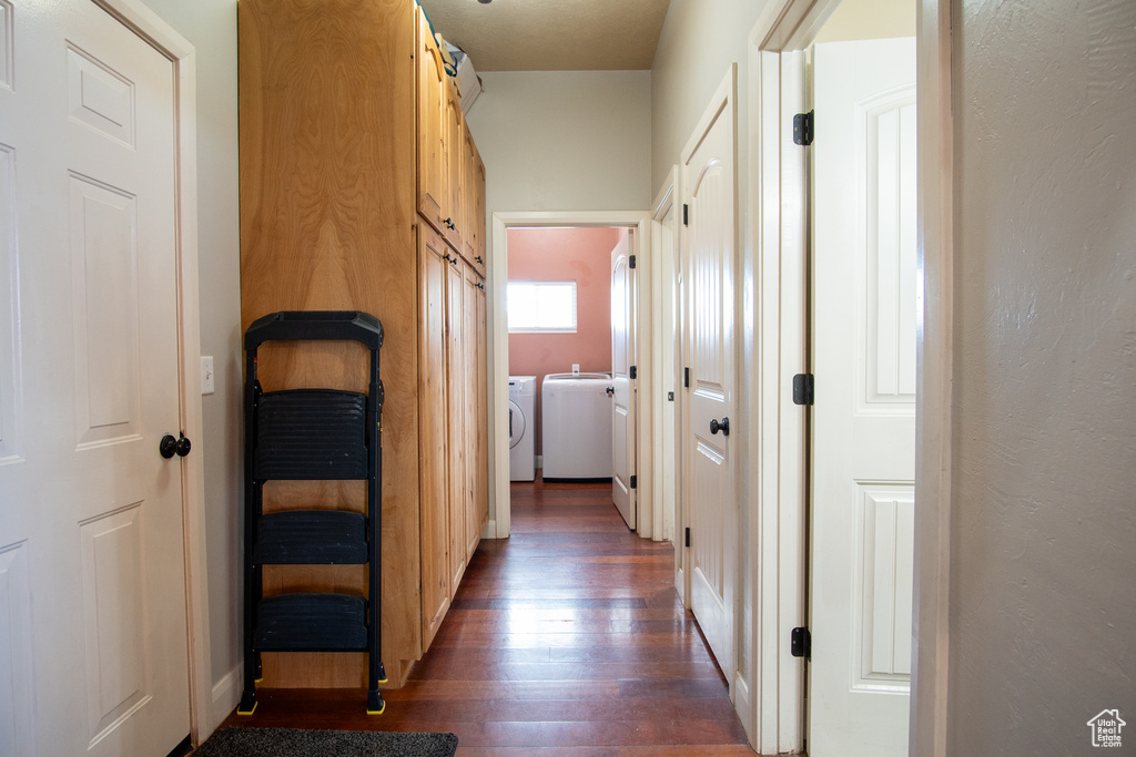 Hall featuring wood finished floors, washing machine and clothes dryer, and baseboards