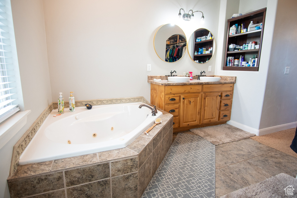Full bathroom featuring a jetted tub and double vanity