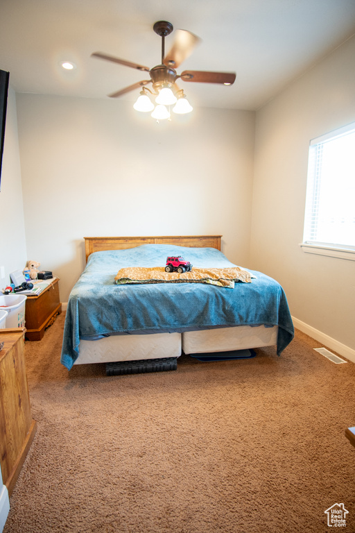Carpeted bedroom featuring baseboards, ceiling fan, and recessed lighting