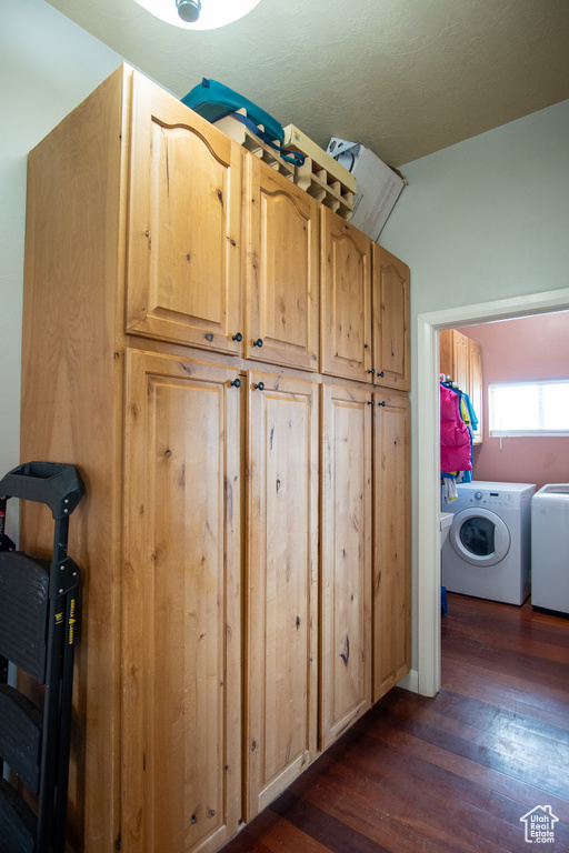 Washroom featuring dark wood finished floors and washing machine and dryer