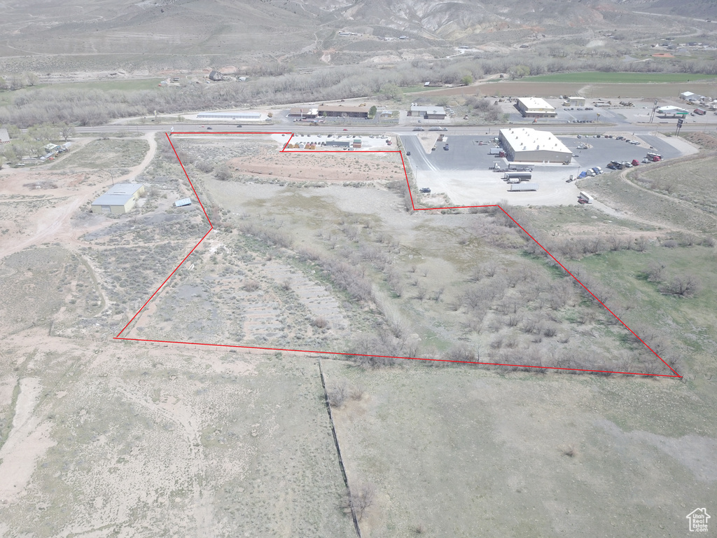 Aerial overview of property's location with property parcel outlined and a mountainous background