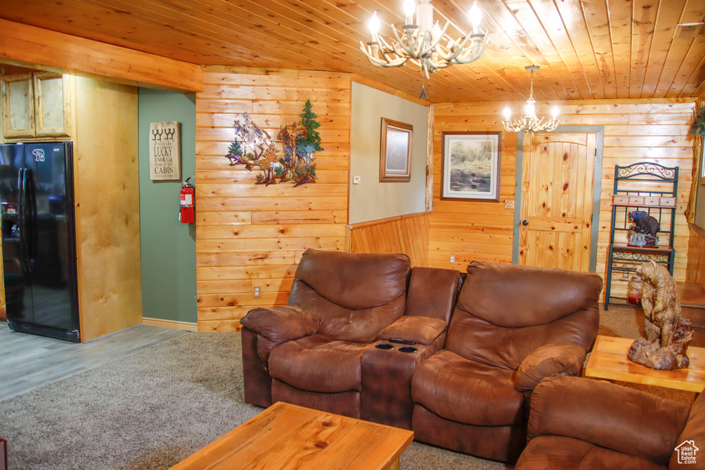 Living area featuring a chandelier, wood walls, wooden ceiling, and wood finished floors