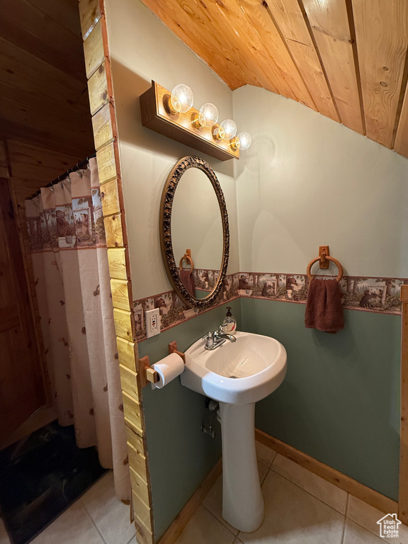 Bathroom featuring wooden ceiling, tile patterned flooring, lofted ceiling, and a shower with curtain