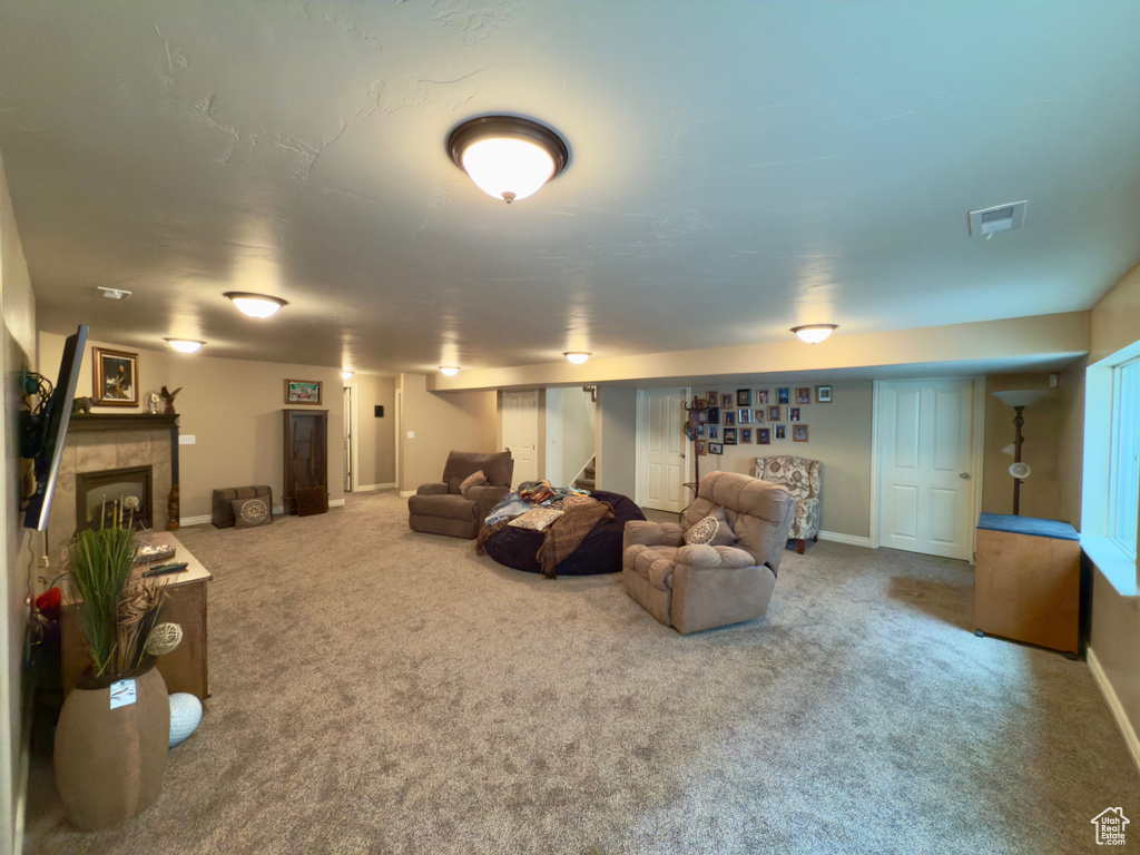 Living room with carpet, stairway, baseboards, and a tile fireplace