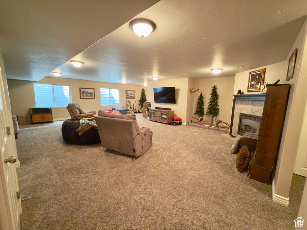 Carpeted living area featuring a tiled fireplace
