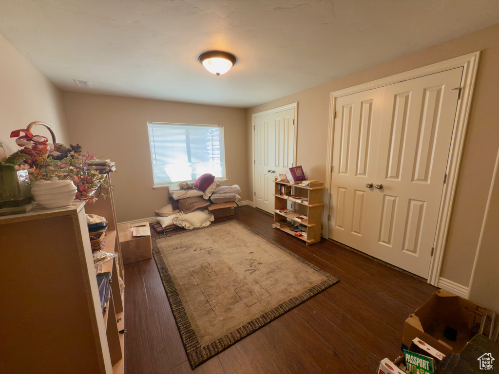 Living area featuring dark wood-style flooring and baseboards