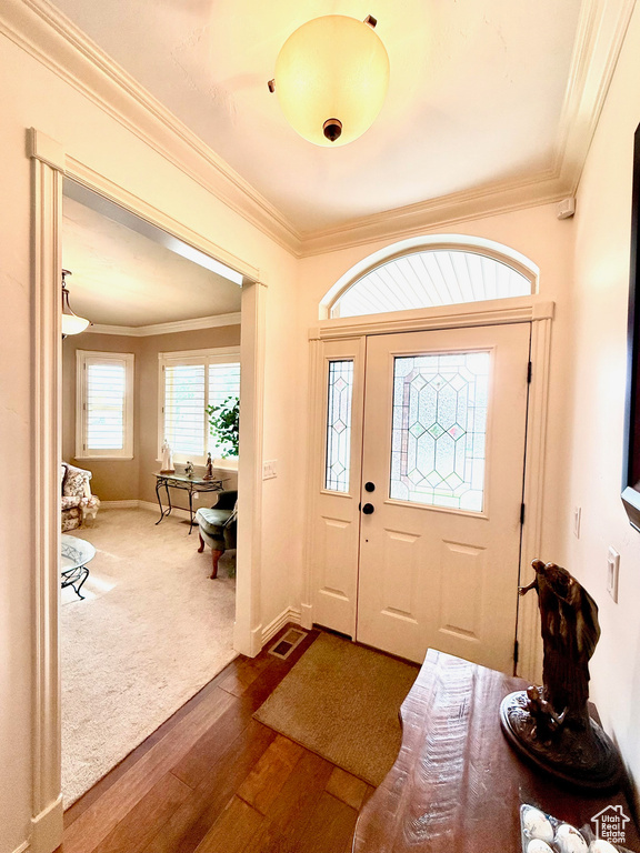 Foyer featuring ornamental molding, dark wood finished floors, and baseboards