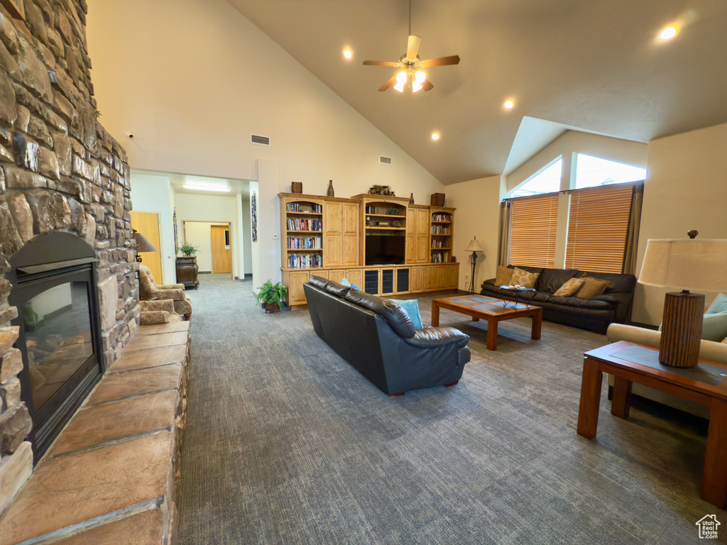 Living room featuring high vaulted ceiling, a stone fireplace, ceiling fan, carpet, and recessed lighting