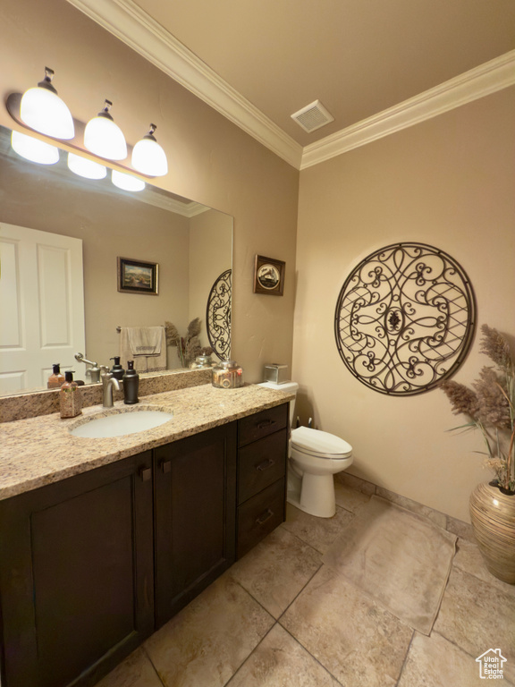 Half bath with crown molding, toilet, vanity, and tile patterned flooring
