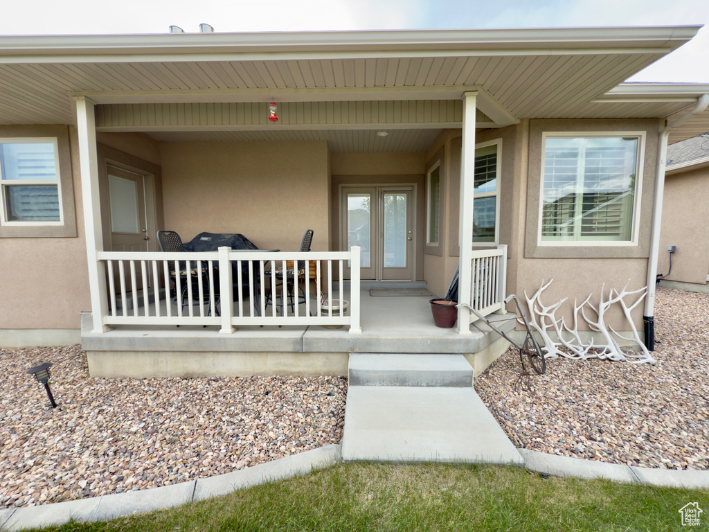 Property entrance with stucco siding and covered porch